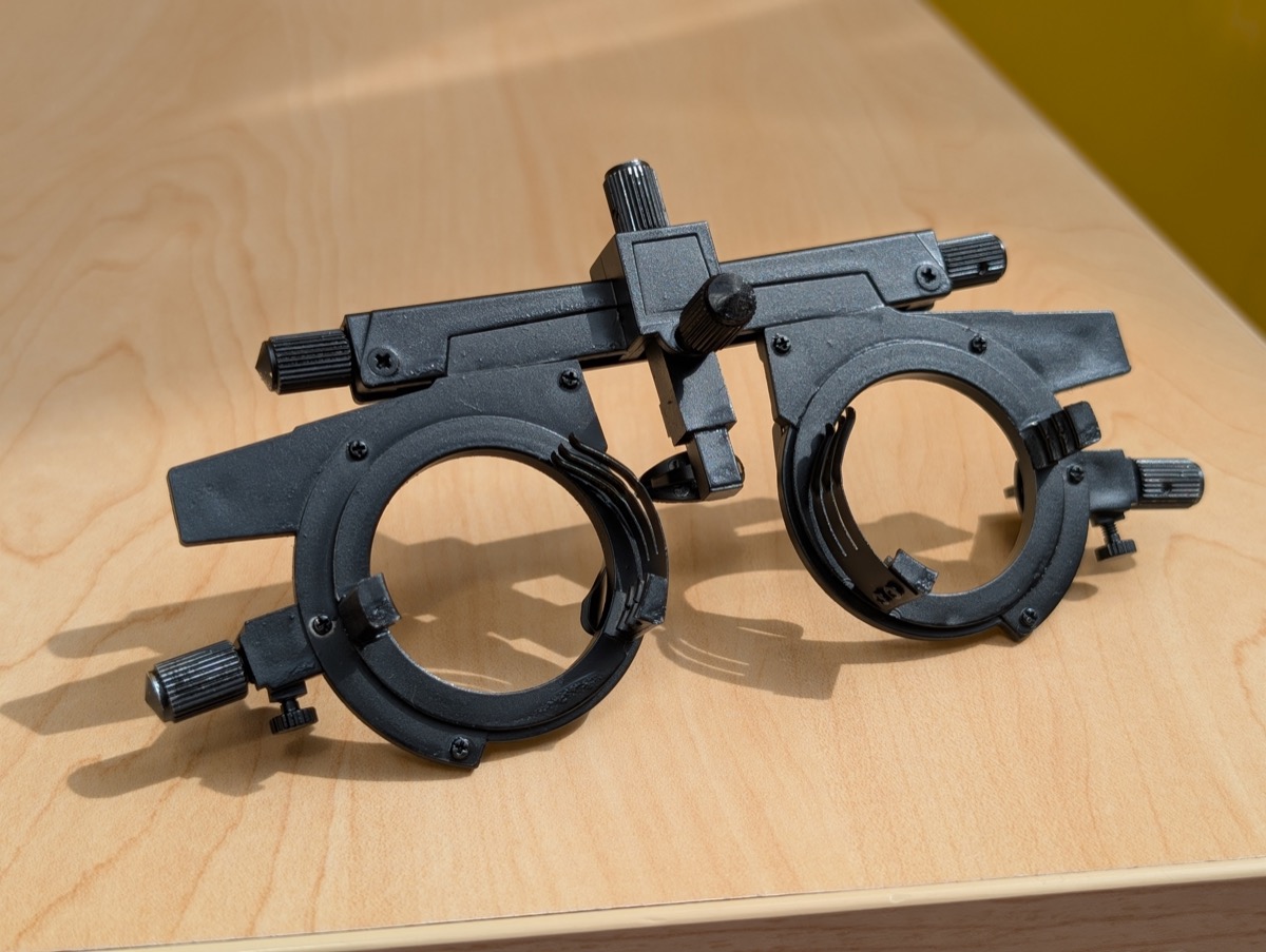 The trial lens frame included with the work, shown empty &mdash; the lenses themselves are customized to the viewer's distance.